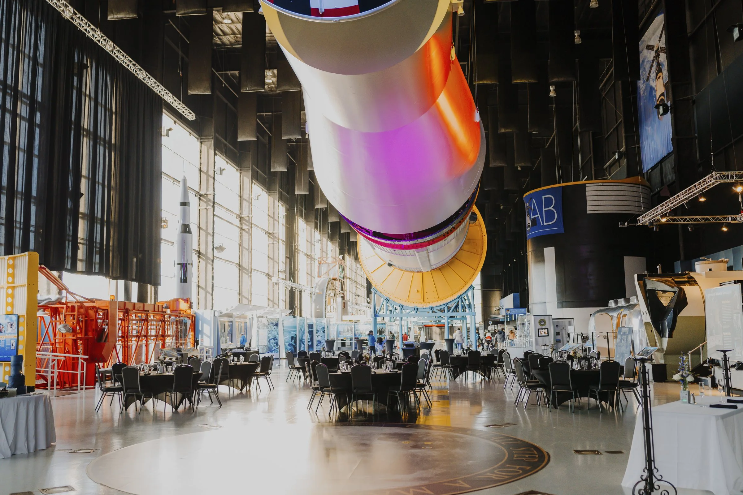 A large event setup beneath a rocket at Saturn V Hall